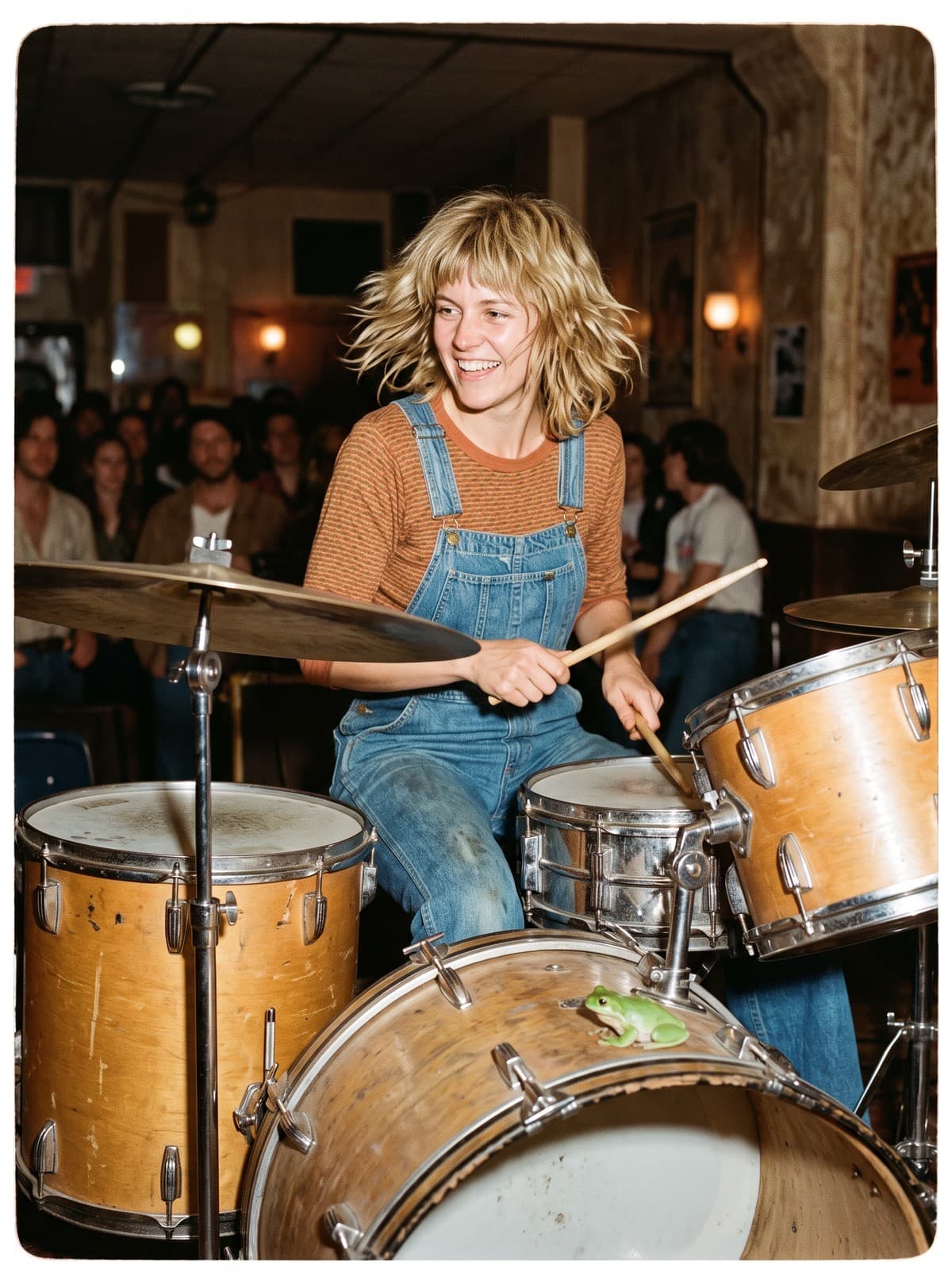 Wren Haskell, short blonde shag and denim overalls, grins as she plays a worn wood-finish drum kit in a crowded hall; a small green frog sits on the bass drum